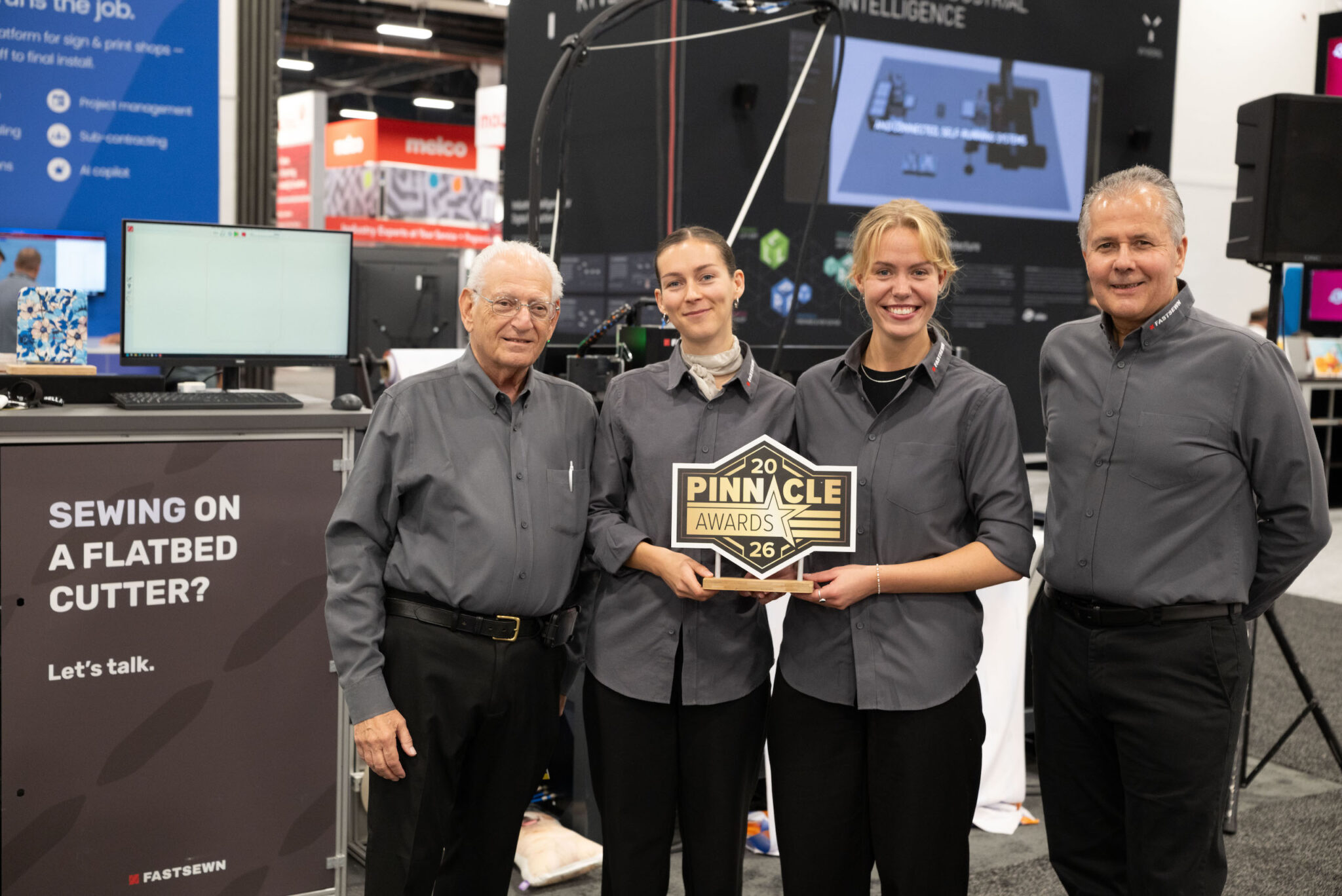 FASTSEWN team members holding the 2026 Pinnacle Award at their stand at PRINTING United 2026